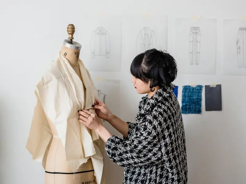 Styliste ajustant une toile sur un mannequin de couture